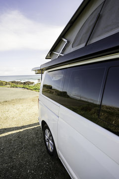 Playa reflejada en el cristal de una furgoneta camper