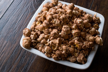 Chocolate Popcorn on dark Wooden Surface.