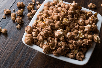Chocolate Popcorn on dark Wooden Surface.