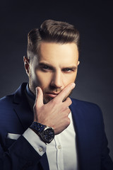 Portrait of handsome business man wearing watch and trendy suit