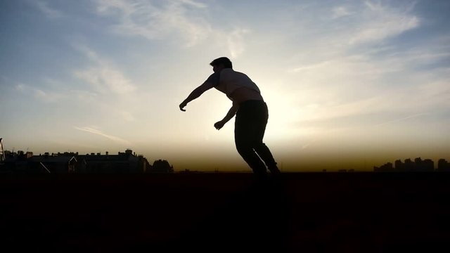 Parkour tricker jumper performs amazing flips, silhouette