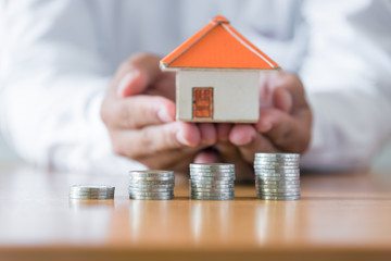 Businessman holding paper home model. Loan concept