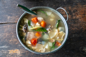 Thai spicy fish soup with herbs, served in big bowl.