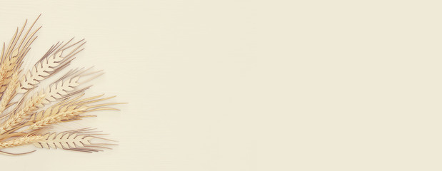 top view of wooden wheat crop decoration over white background. Symbols of jewish holiday - Shavuot.