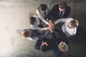 Business people putting their hands together. Concept of integration, teamwork and partnership