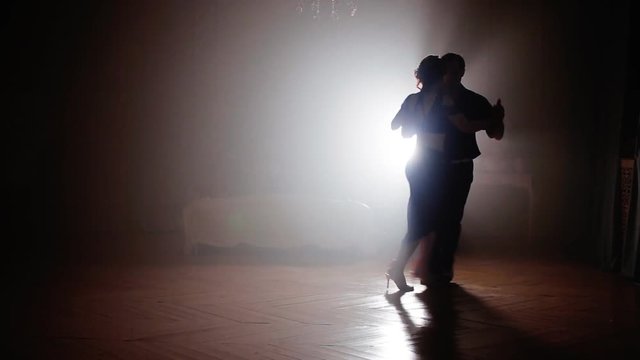 Couple dancing tango in the fog