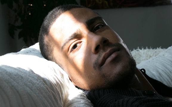 Portrait of a handsome, good looking black man lying down