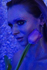 Stunning beautiful naked girl in sparkles make-up in blue with a bouquet of purple tulips - 201629865
