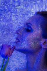 Stunning beautiful naked girl in sparkles make-up in blue with a bouquet of purple tulips - 201629889