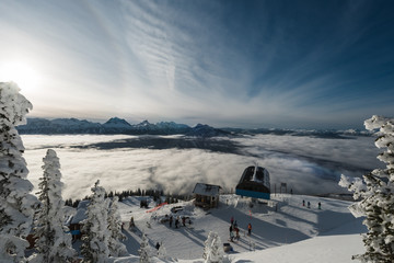 Fototapeta na wymiar Overlooking the clouds and the top gondela at Revelstoke mountain