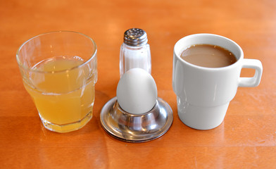 Modest breakfast. Egg, juice, salt and coffee
