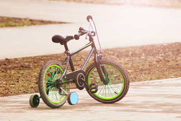 Fototapeta premium Green children's bike at sunset.