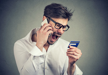 Screaming angry man solving problems with credit card
