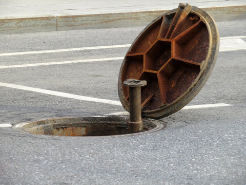 Open manhole on the road. Opened sewer cover, underground repairs