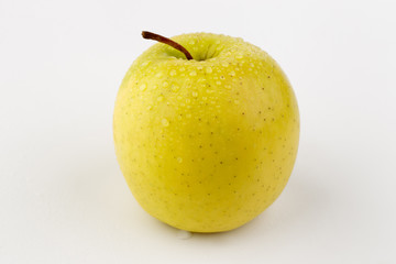 Bright ripe yellow apple in water drops