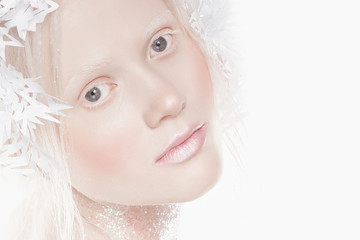 A very delicate portrait of an albino girl, a white background, snowflakes in her hair, sparkles, a magical winter image. Natural make-up, pink lipstick on lips.