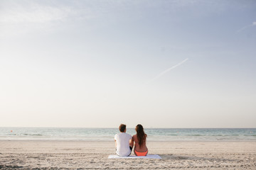 Love. Beautiful couple sitting on the seashore together
