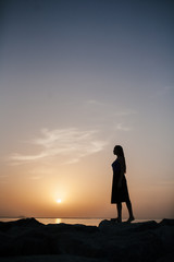 Beautiful girl on a sunset background on a sandy beach