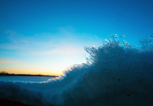 Frozen ice in the spring at sunset.