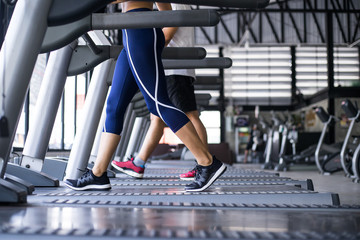 Fototapeta premium Young beautiful lady fitness training with other guy in gym