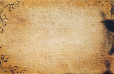 A wooden board with wrinkled colors and a drawing caused. Textured background view from the top. Free space for text.