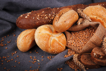Fresh fragrant bread on the table. Food concept. Bakery, crusty loaves of bread and buns. Assortment of baked bread
