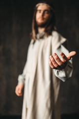 Jesus Christ in white robe reaching out his hand