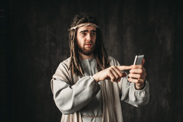 Man in the image of Jesus Christ holds phone