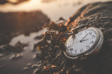 Old clock on a rock by the ocean