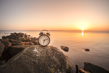 Alarm clock in the sunrise by the sea