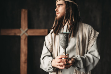 Fototapeta na wymiar Jesus Christ holds a cup of wine