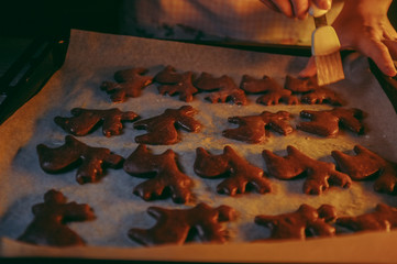 Naklejka na ściany i meble woman preparing a Christmas reindeer gingerbread biscuits, candlelight