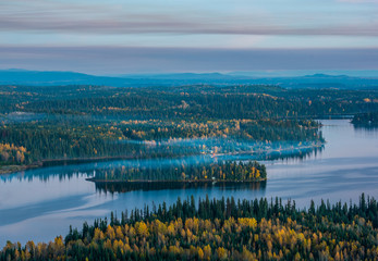 A hazy island in summit lake covered in fall colors. Shot at dusk from the top of Teapot mountain -...