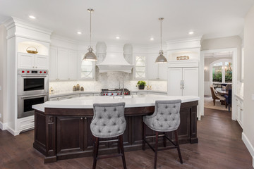 Kitchen in new luxury home: large, elegant kitchen, with pendant lights, huge island, and view of...