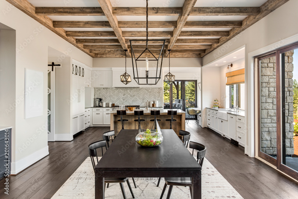 Wall mural Stunning dining room and kitchen in new luxury home.Wood beams and elegant pendant lights accent this beautiful open-plan dining room and kitchen