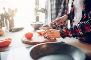 Wife and husband cooking vegetable salad in bowl