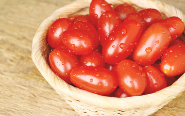 Colorful 3 kind of tomatoes in basket on wooden floor