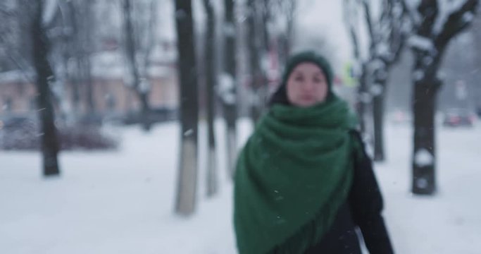 Slow motion portrait of teen girl walking on street on a winter day