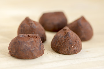 Delicious brown chocolate truffles on wooden table, very tasty sweets