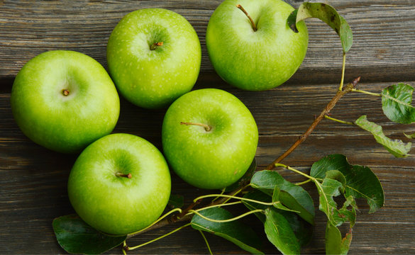 Health Benefits Of Green Apples.
Green apples with leaf on wooden background