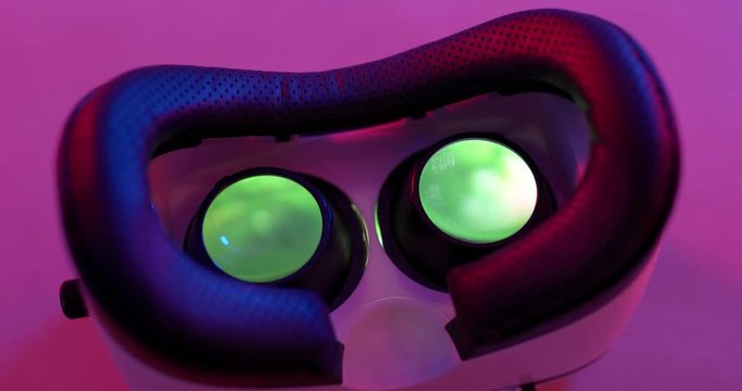 Virtual reality device with video playing inside under purple lighting