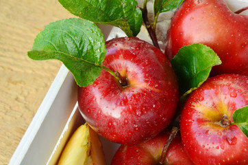 Red apple or Gala apple group with slice and water drop in white wooden box on wooden background