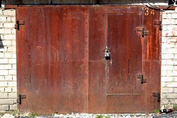 Rusty garage doors with padlock.