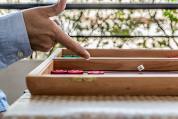 Playing backgammon on a wooden board with dices