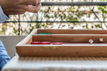 Playing backgammon on a wooden board with dices