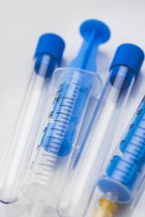 Syringes and test tubes lying on a white table. Medical background concept.