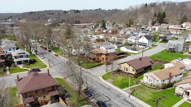 A slow daytime late winter aerial establishing shot of a typical residential neighborhood in a Western Pennsylvania small town. Pittsburgh suburbs.  	
