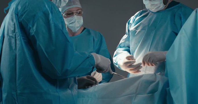 MED Medical team, doctors performing surgical operation in real modern operating theater. 4K UHD 60 FPS SLO MO