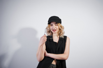 Naklejka premium Studio portrait of blonde girl in black wear and cap against white background.