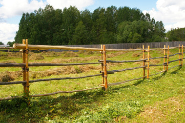 Wooden fence in field of hay rural landscape 